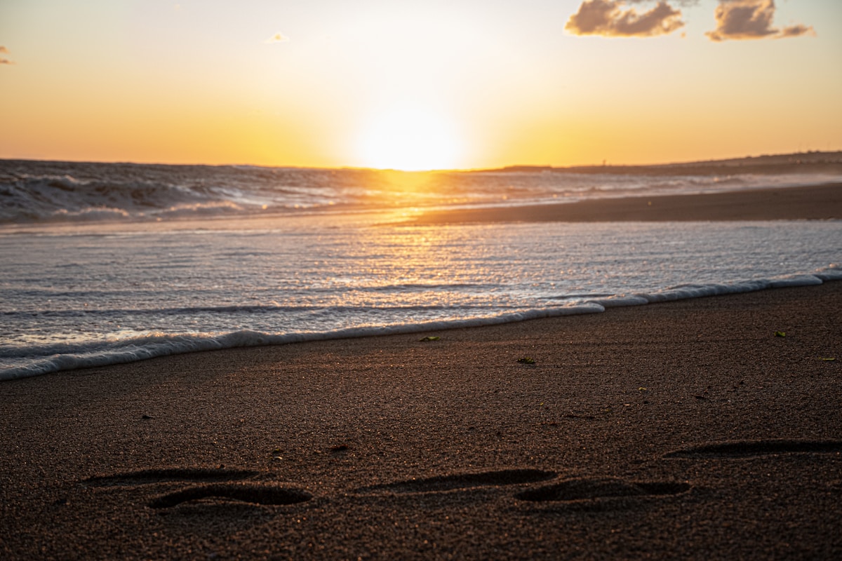 Pegadas na areia durante o pôr do sol